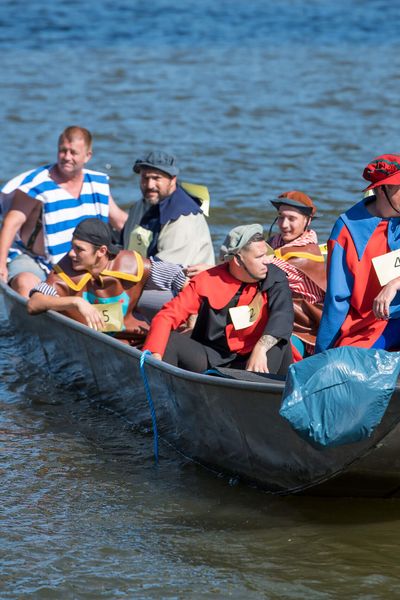 Kostümierte Teilnehmer*innen sitzen in einem Boot auf dem Main, sonniges Wetter.