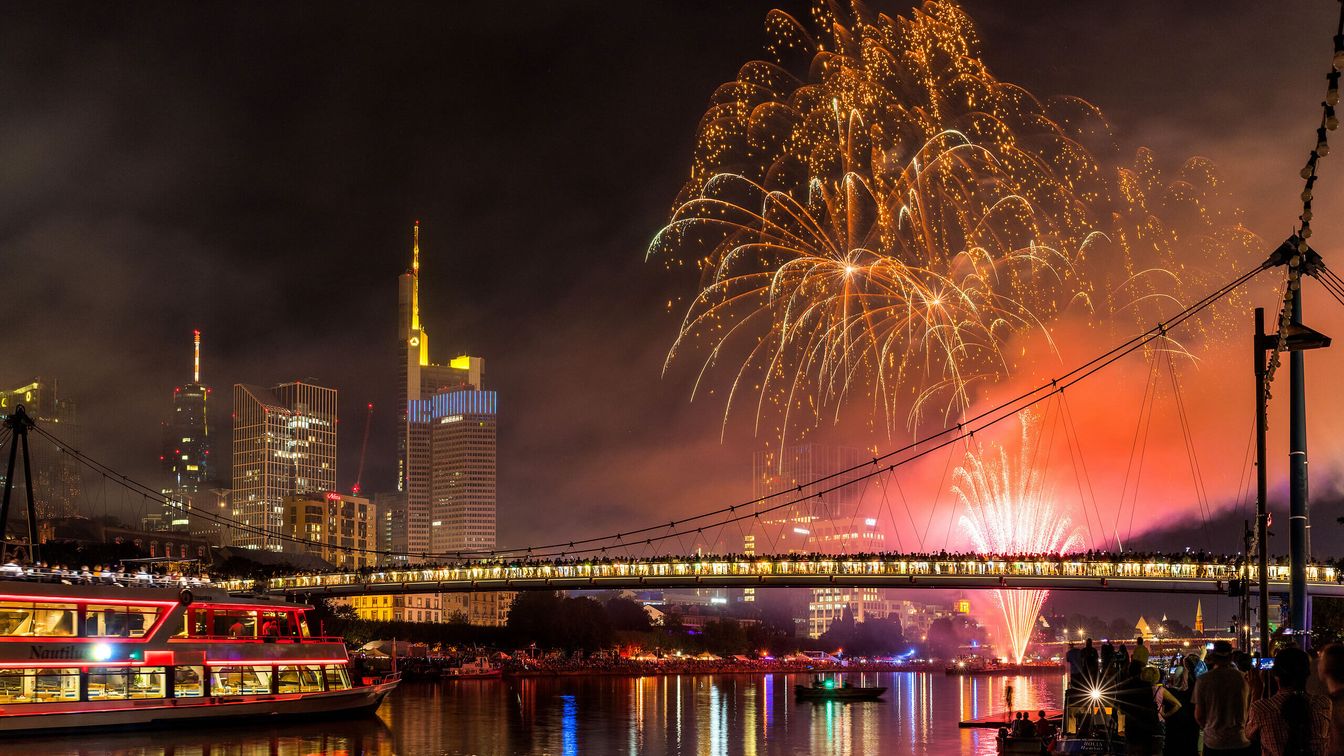 Buntes Feuerwerk erhellt den Himmel über Frankfurt am Main während des Abschlusses des Museumsuferfestes, die beleuchtete Skyline und der Main sind ebenfalls zu sehen.