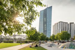 Blick auf den Hafenpark in Frankfurt mit Skatepark, Bäumen und der Europäischen Zentralbank im Hintergrund, bei sonnigem Wetter und lebendigem Treiben.