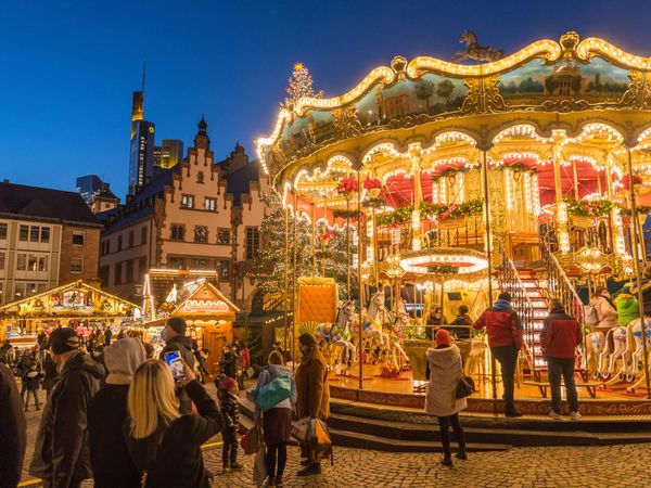 Beleuchtetes Karussell auf dem Weihnachtsmarkt am Abend.