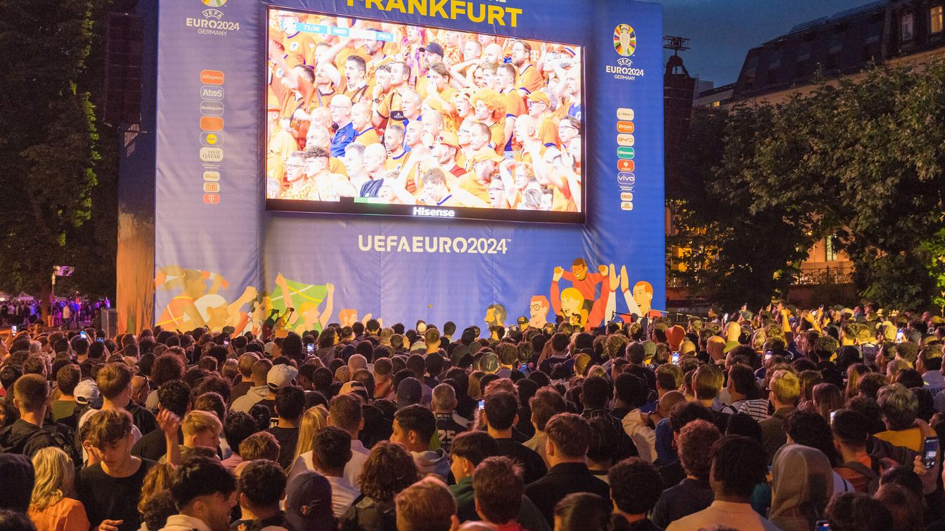 Fans schauen auf einen Bildschirm, auf dem das Spiel Frankreich - Niederlande gezeigt wird. 