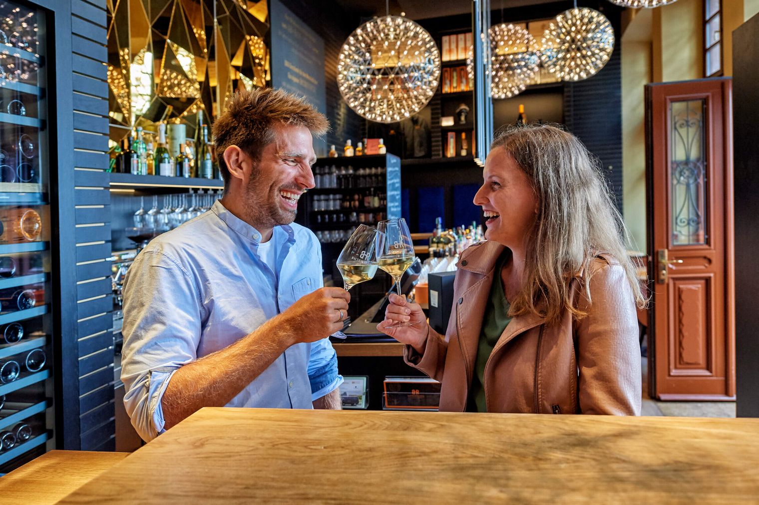 Ein Paar stößt mit Weingläsern in einem Weinlokal an