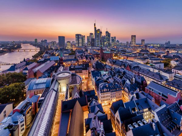 Blick vom Kaiserdom auf die Frankfurter Neue Altstadt, den Main und die Skyline in der Abenddämmerung.