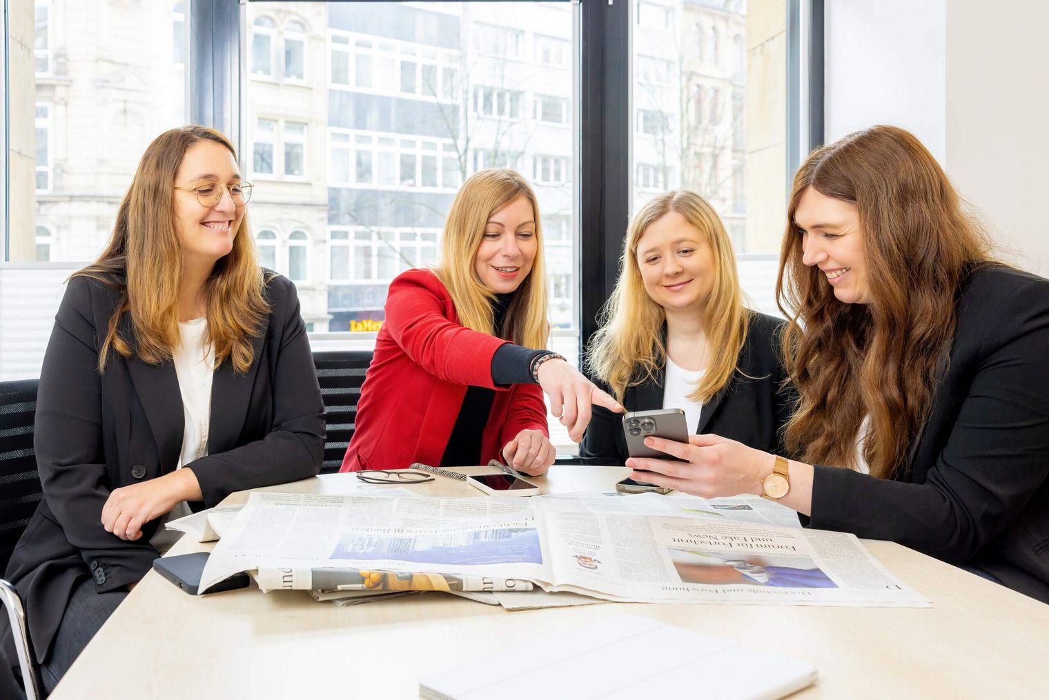 Kollegen des Presseteams sitzen an einem Tisch zusammen.