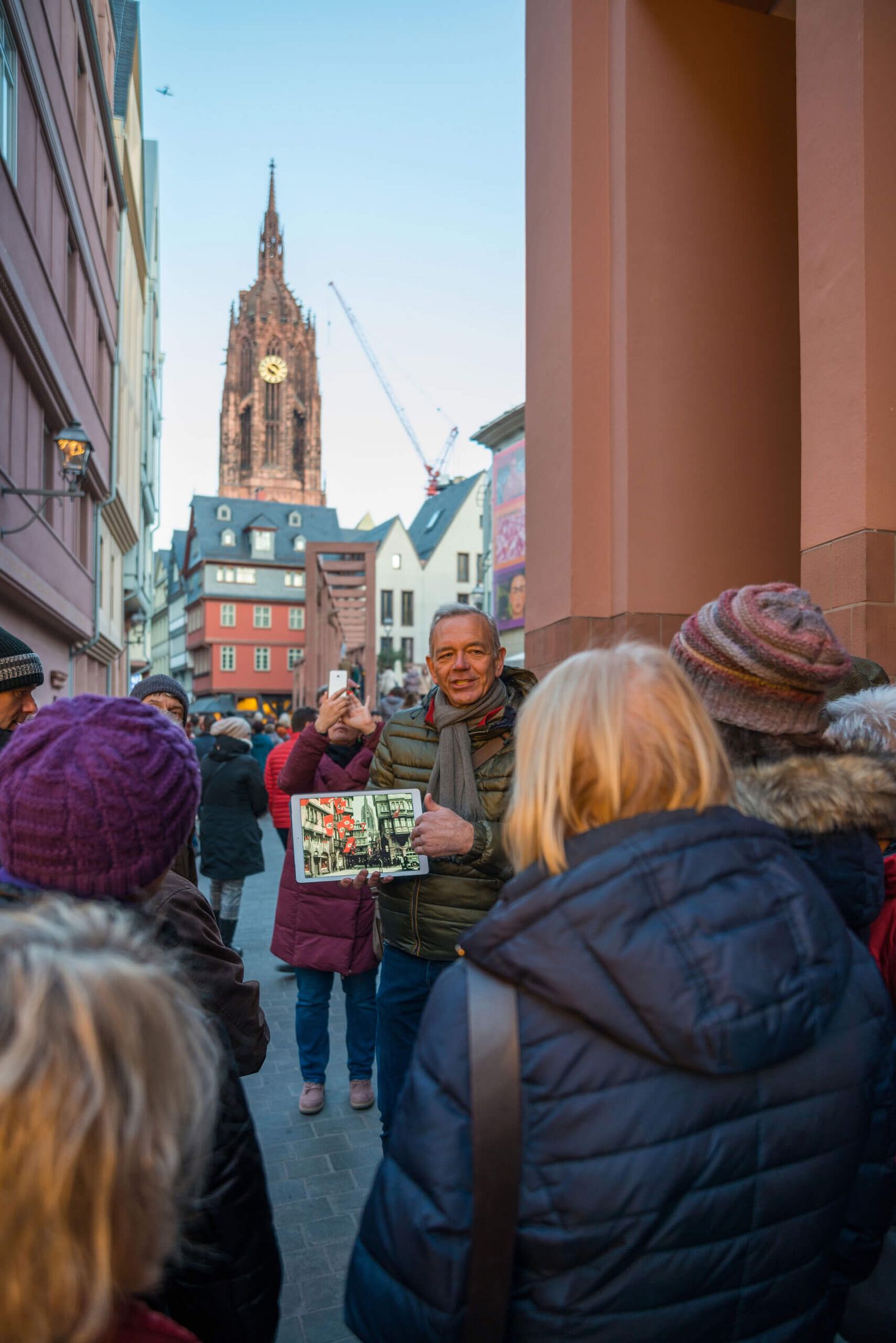 Gästeführer erzählt Gästen von der neuen Altstadt mit Blick auf den Kaiserdom