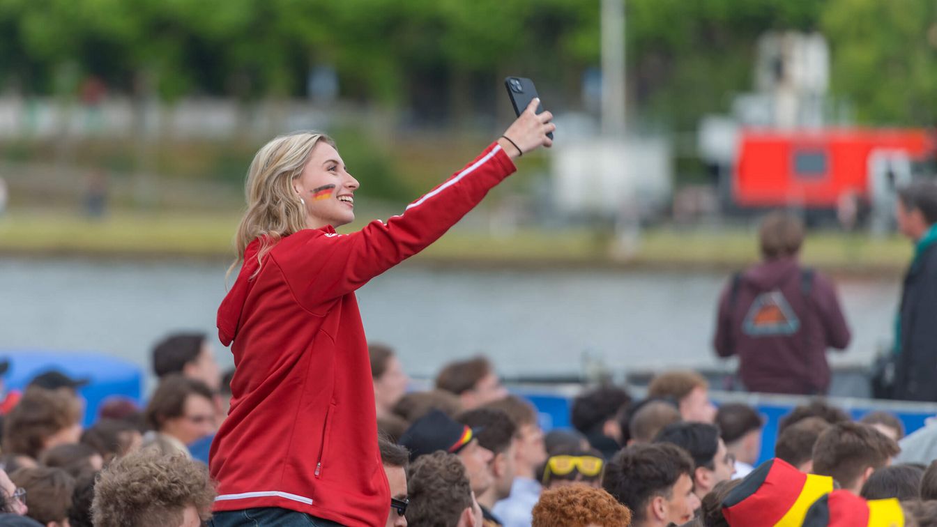 View of a young lady among the football fans during the Germany vs. Scotland match at the UEFA EURO 2024 at the Fan Zone Mainufer in Frankfurt..