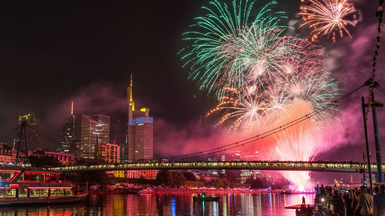 Das Abschlussfeuerwerk des Museumsuferfestes erleuchtet den Nachthimmel über dem Main in Frankfurt, mit bunten Feuerwerkskörpern und einer erleuchteten Skyline im Hintergrund.