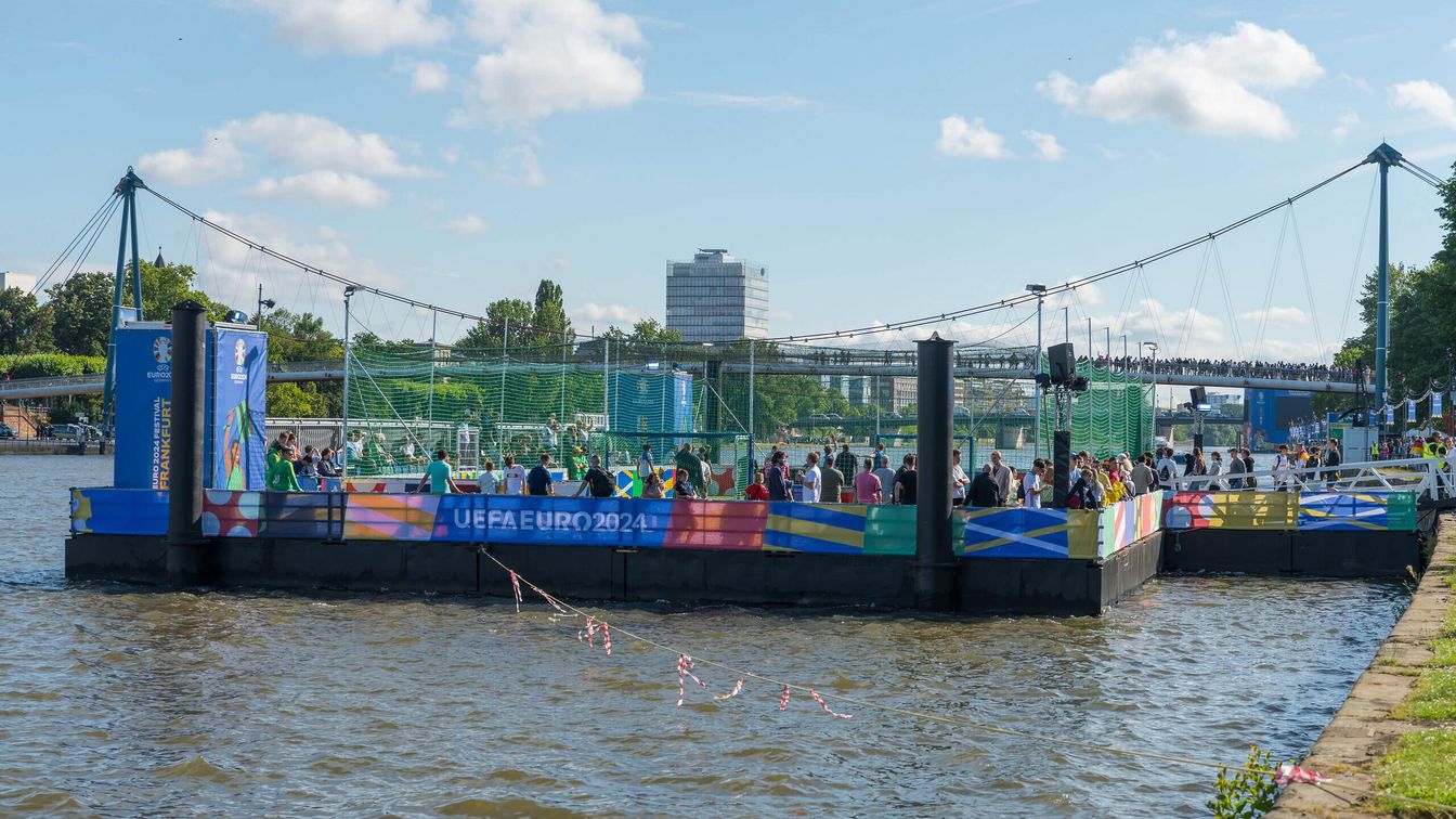 Blick auf den Floating Pitch. Das schwimmende Fußballfeld auf dem Main während der UEFA EURO 2024 auf der Fan Zone Mainufer in Frankfurt.